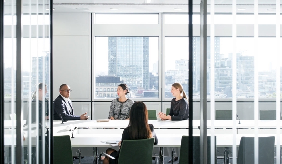 Four people meeting in glass office